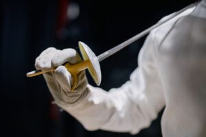 Fencer in protective jacket showing underarm construction and shoulder mobility