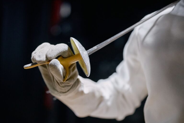 Fencer in protective jacket showing underarm construction and shoulder mobility
