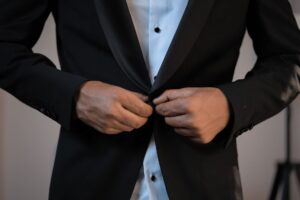 Close-up of the back of a structured tailored jacket showing a clean vent with a small anchor button at the base