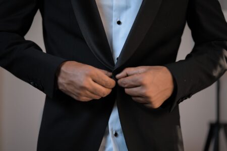Eton College Tails Coat Tail Buttons Are Quietly Anchoring Structured Back Vents Close-up of the back of a structured tailored jacket showing a clean vent with a small anchor button at the base