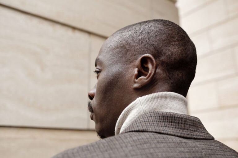 Close-up of a structured men's jacket with squared shoulder epaulette detail