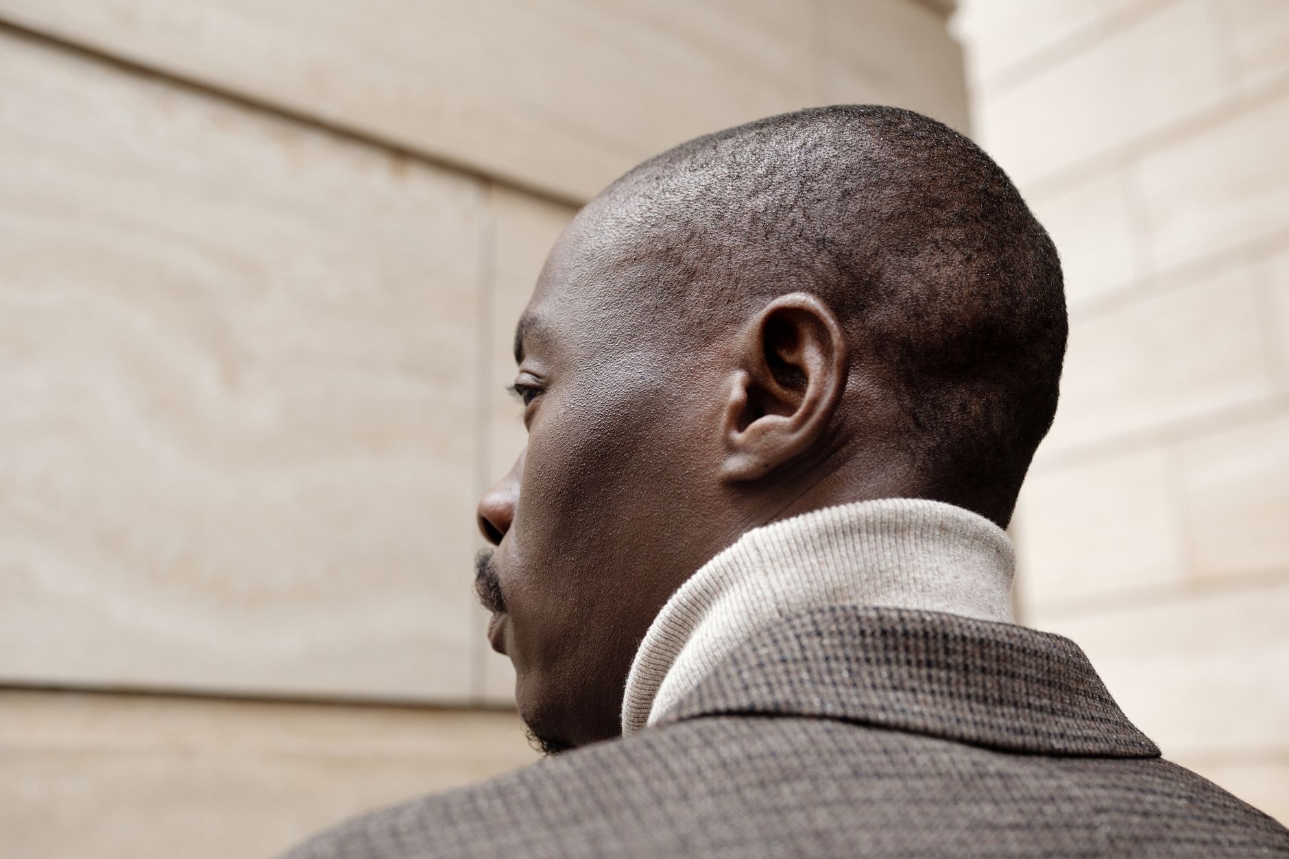 Close-up of a structured men's jacket with squared shoulder epaulette detail