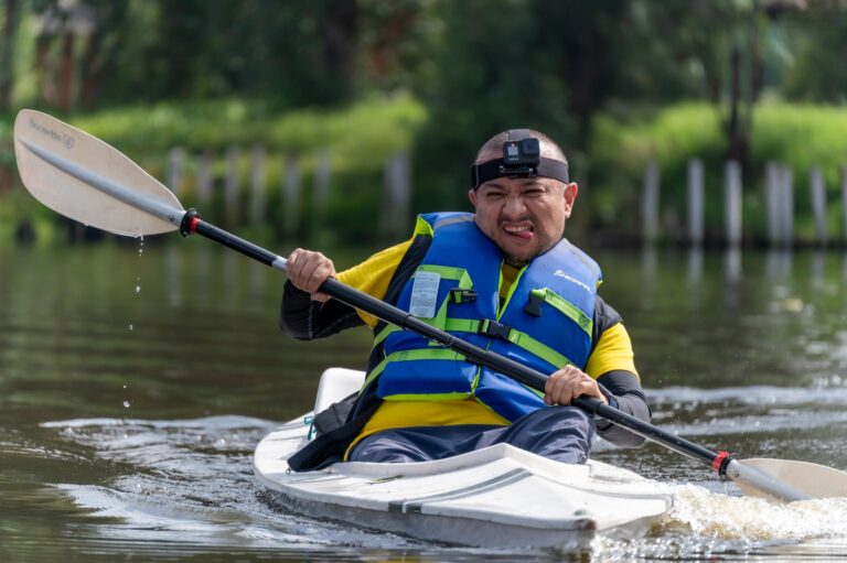 Close-up of a kayak paddle shaft over calm flat water