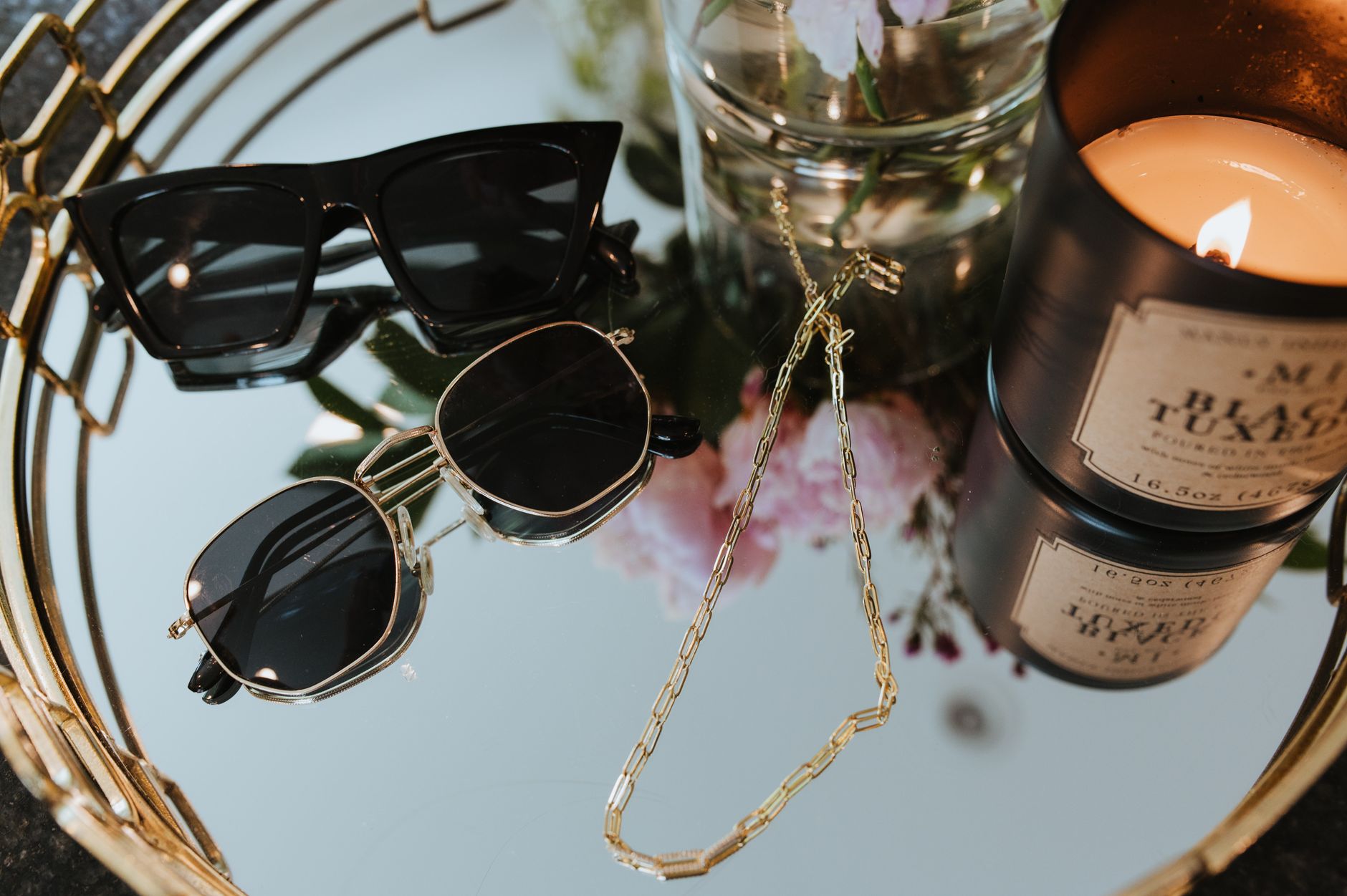 Close-up of layered gold chain necklaces with interlocking hardware links on a neutral background