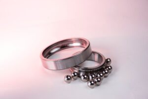 Close-up of polished metal O-rings and D-rings arranged on a flat surface, showing equestrian-style hardware details