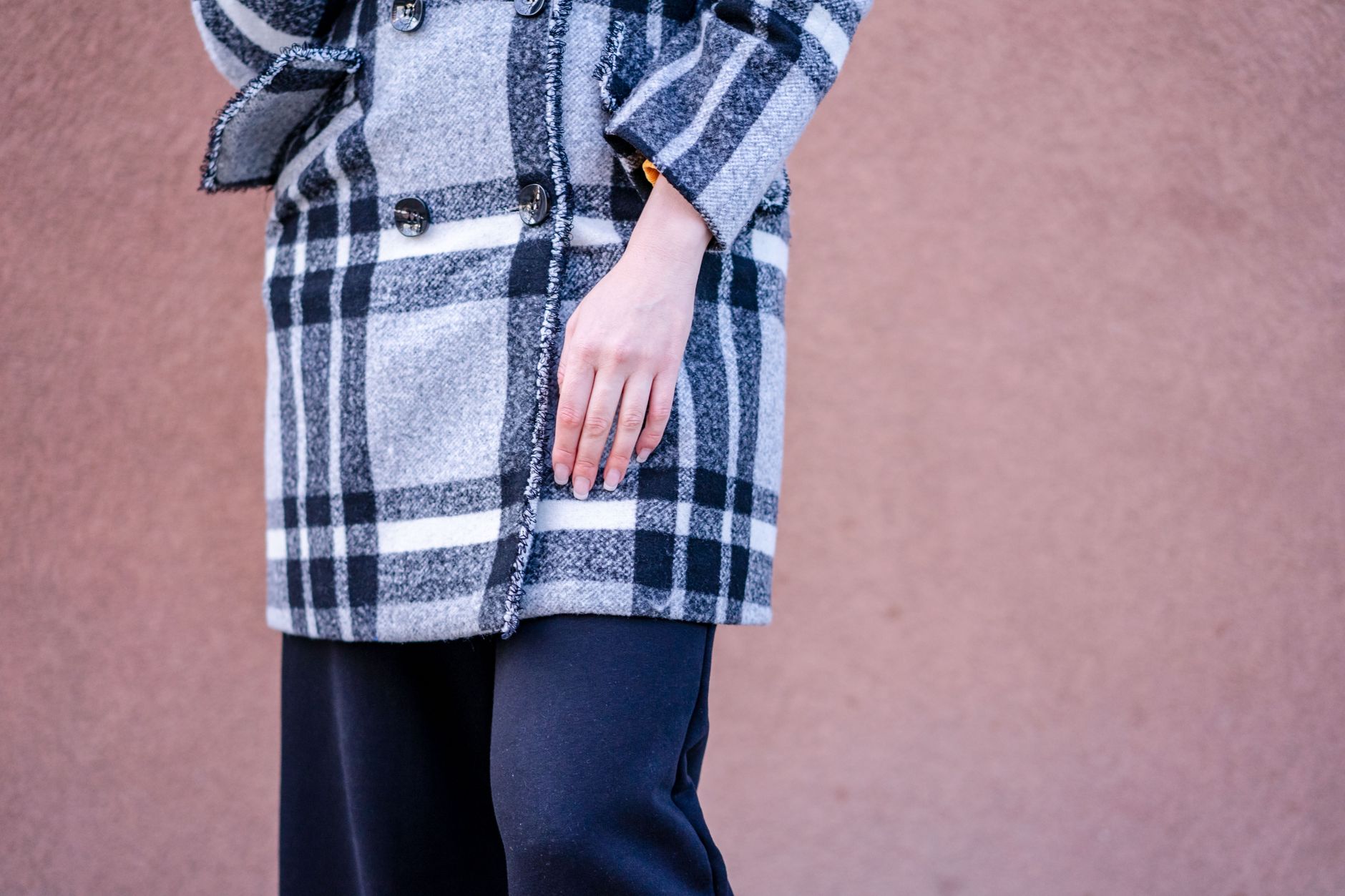 A structured tailored coat with clean lapels and a sharp silhouette displayed on a clothing rack