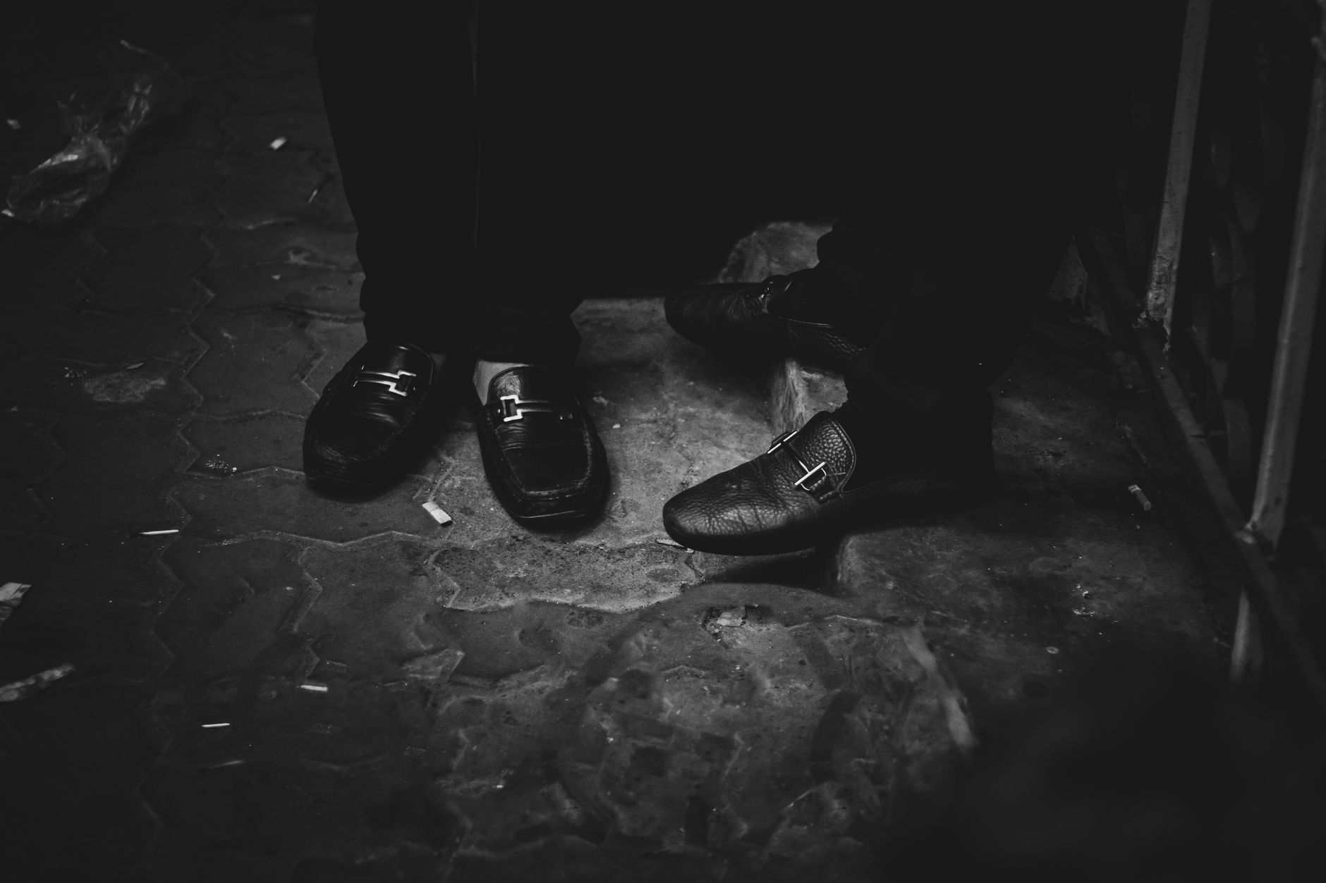 Minimalist shoe detail showing a single narrow strap across the ankle with matte hardware
