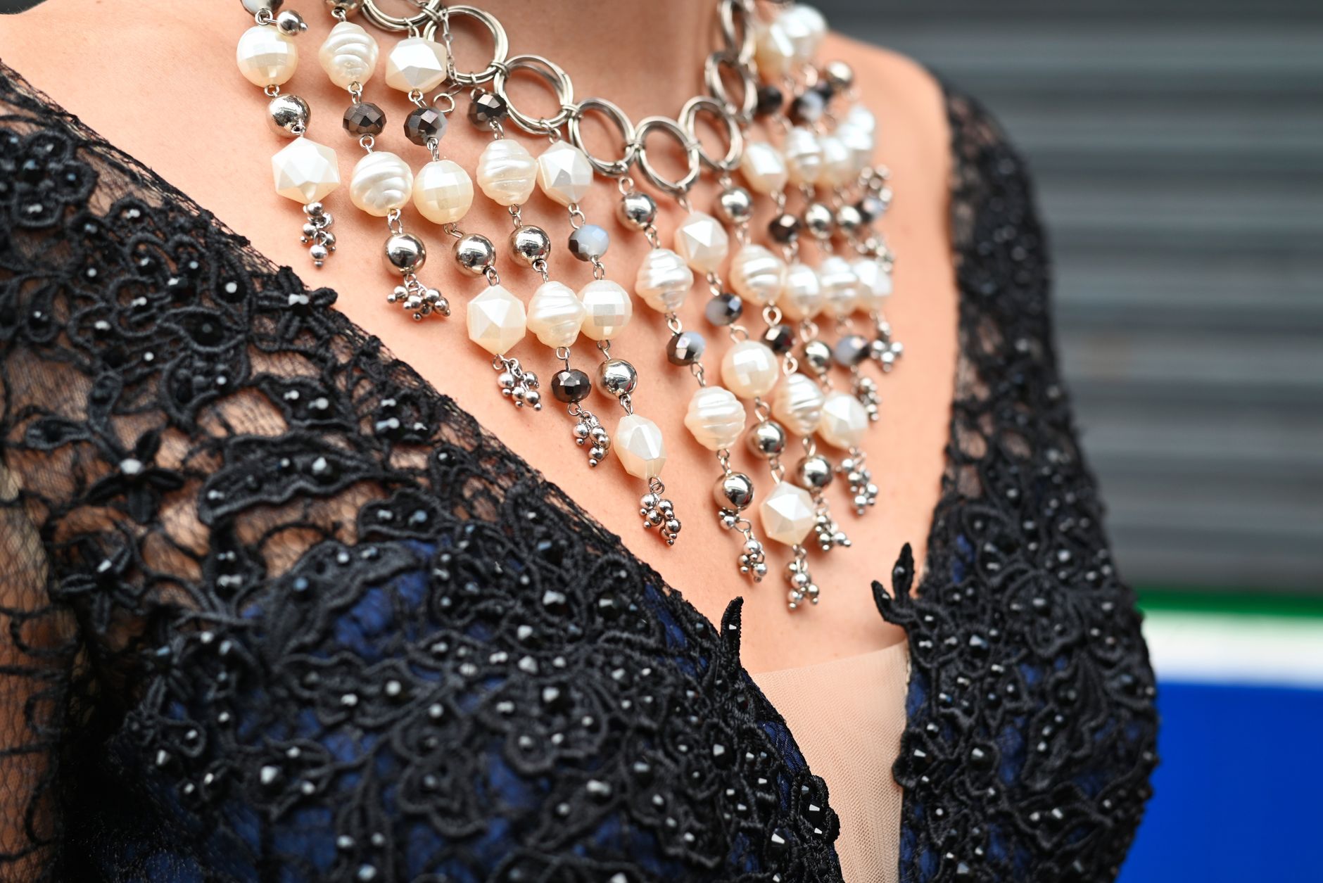 Structured bib necklace with geometric surface detailing worn against a collarbone