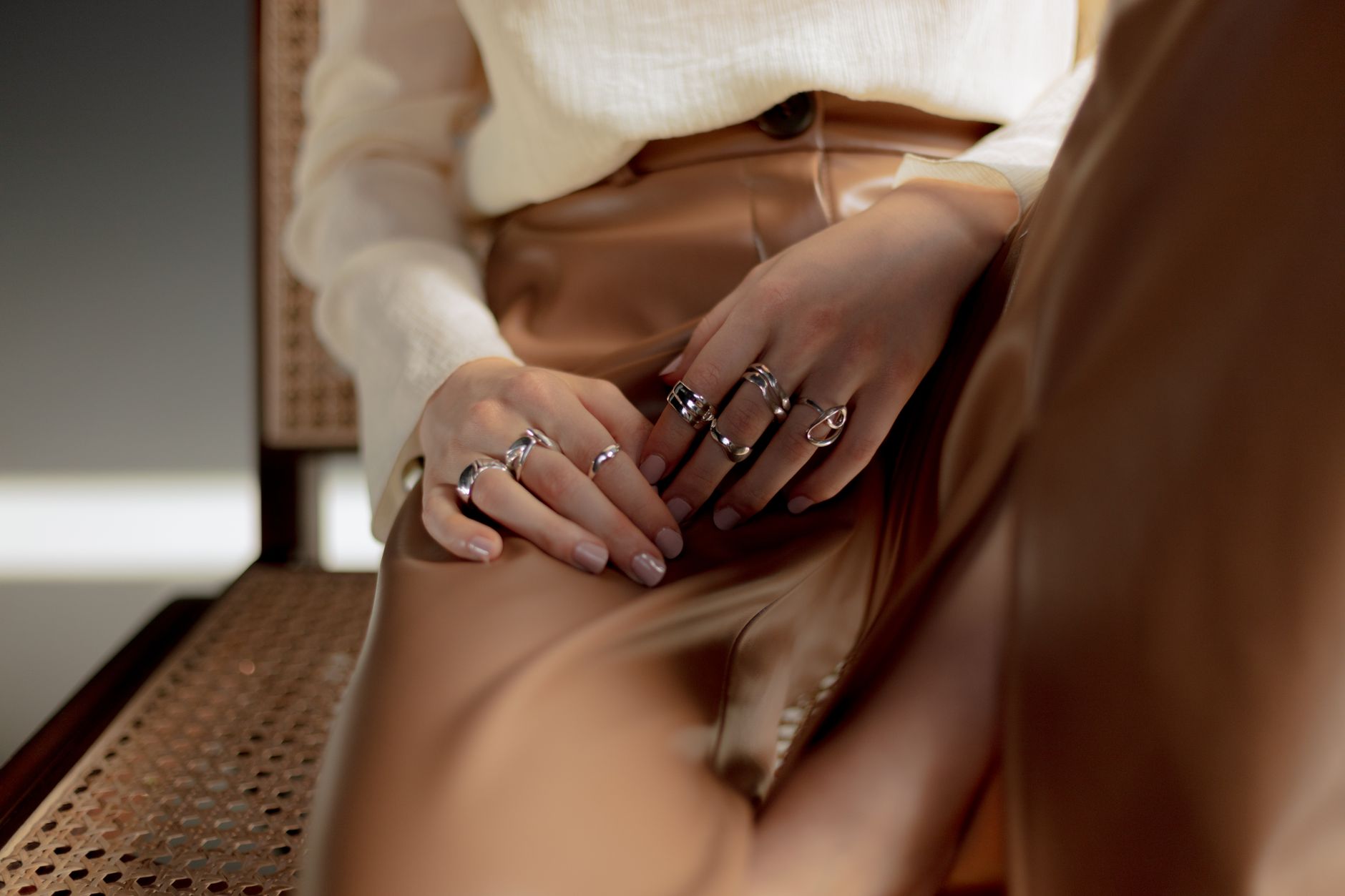 Minimalist silver rings stacked on a neutral surface showing industrial-inspired hardware design