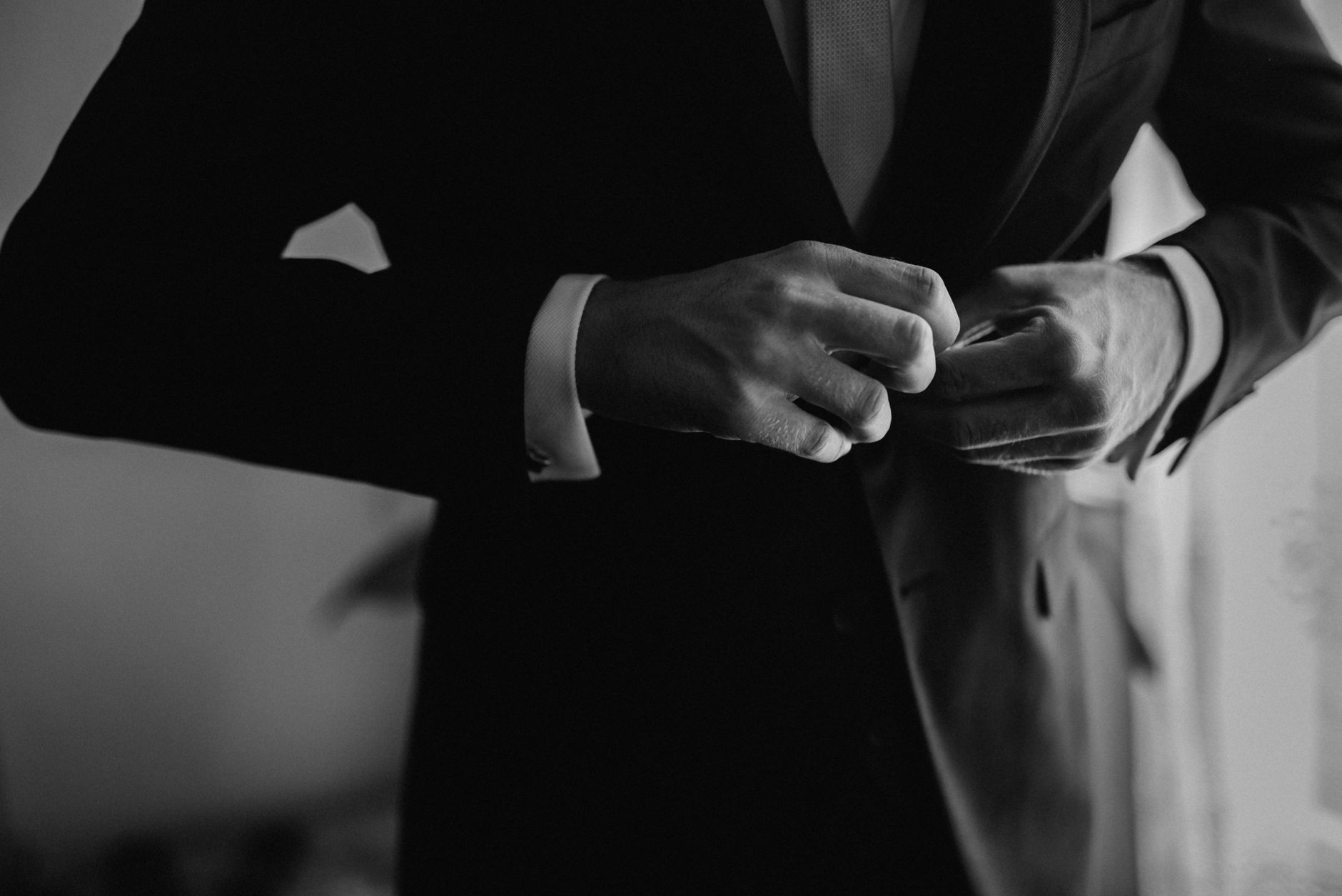 Close-up of a structured blazer cuff with contrast binding detail on tailored fabric