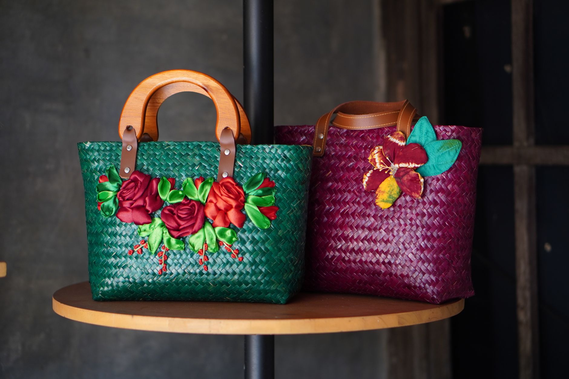 Top-handle structured bag showing wrapped grip detail with exposed termination hardware at the base