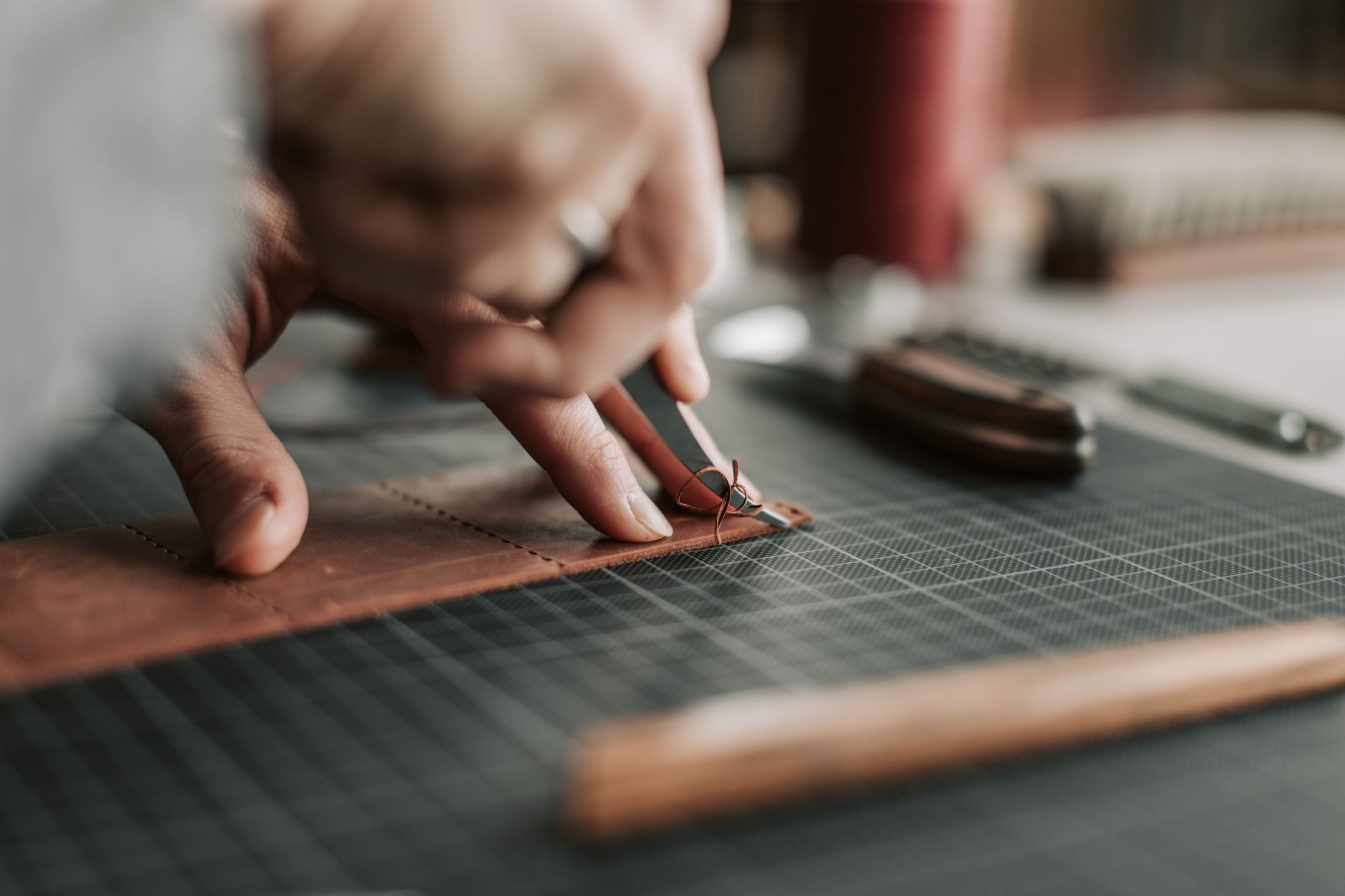 Artisan leather stitching on a curved edge showing saddle stitch technique