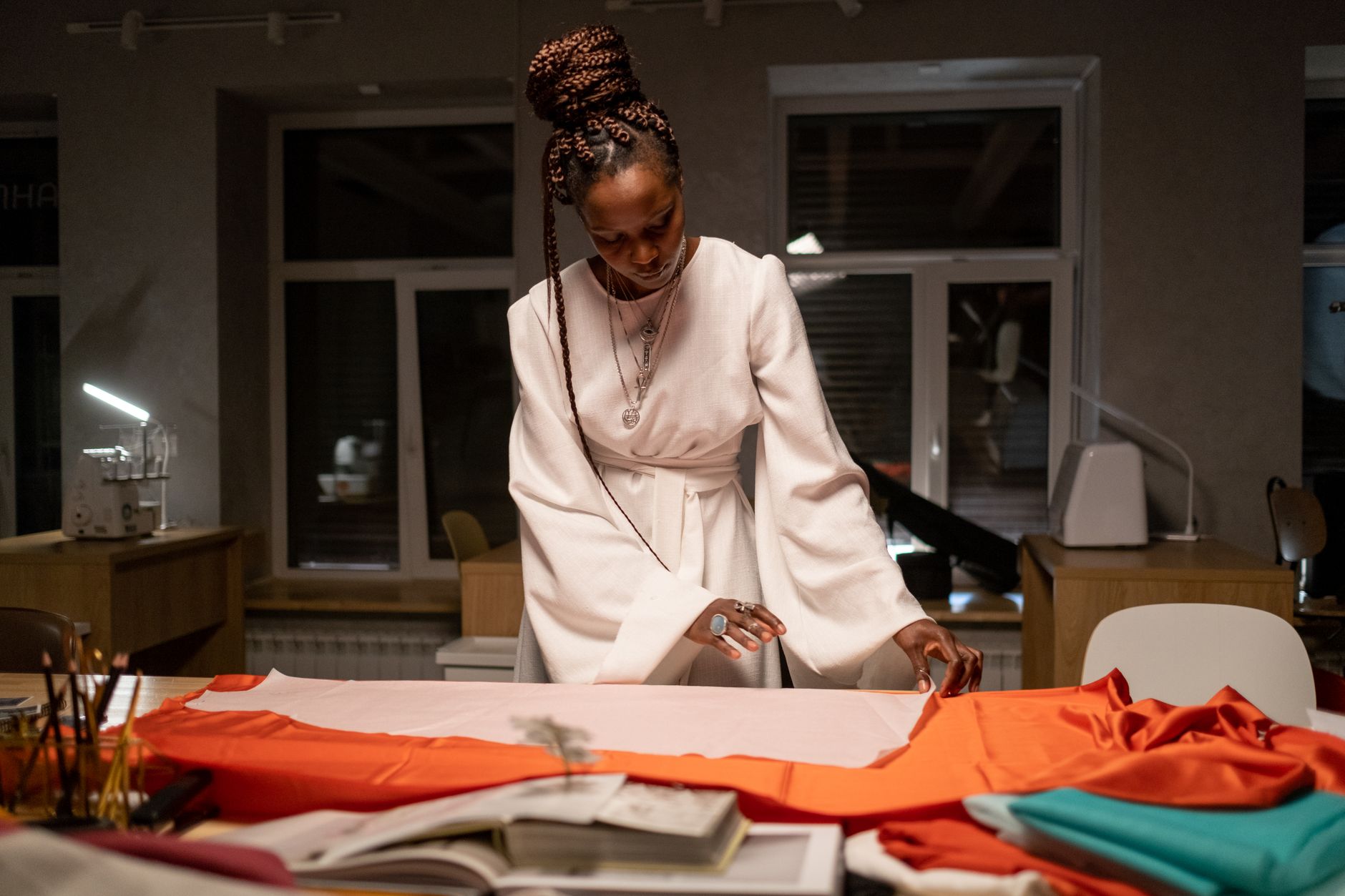 Fashion designer examining structured garment waistband construction in a studio setting