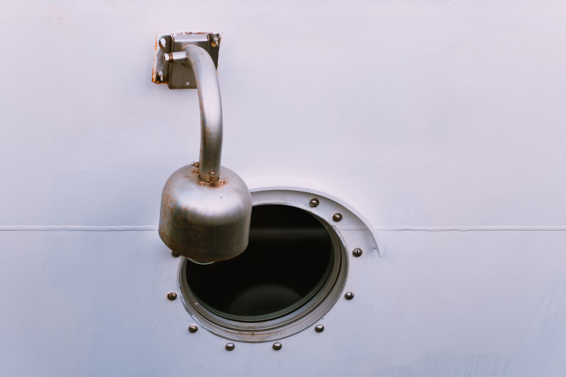 Stainless steel marine bolts and bracket components arranged on a flat surface