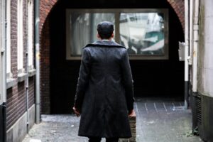 Close-up of the structured back vent on a formal tailored coat showing precise pleat construction