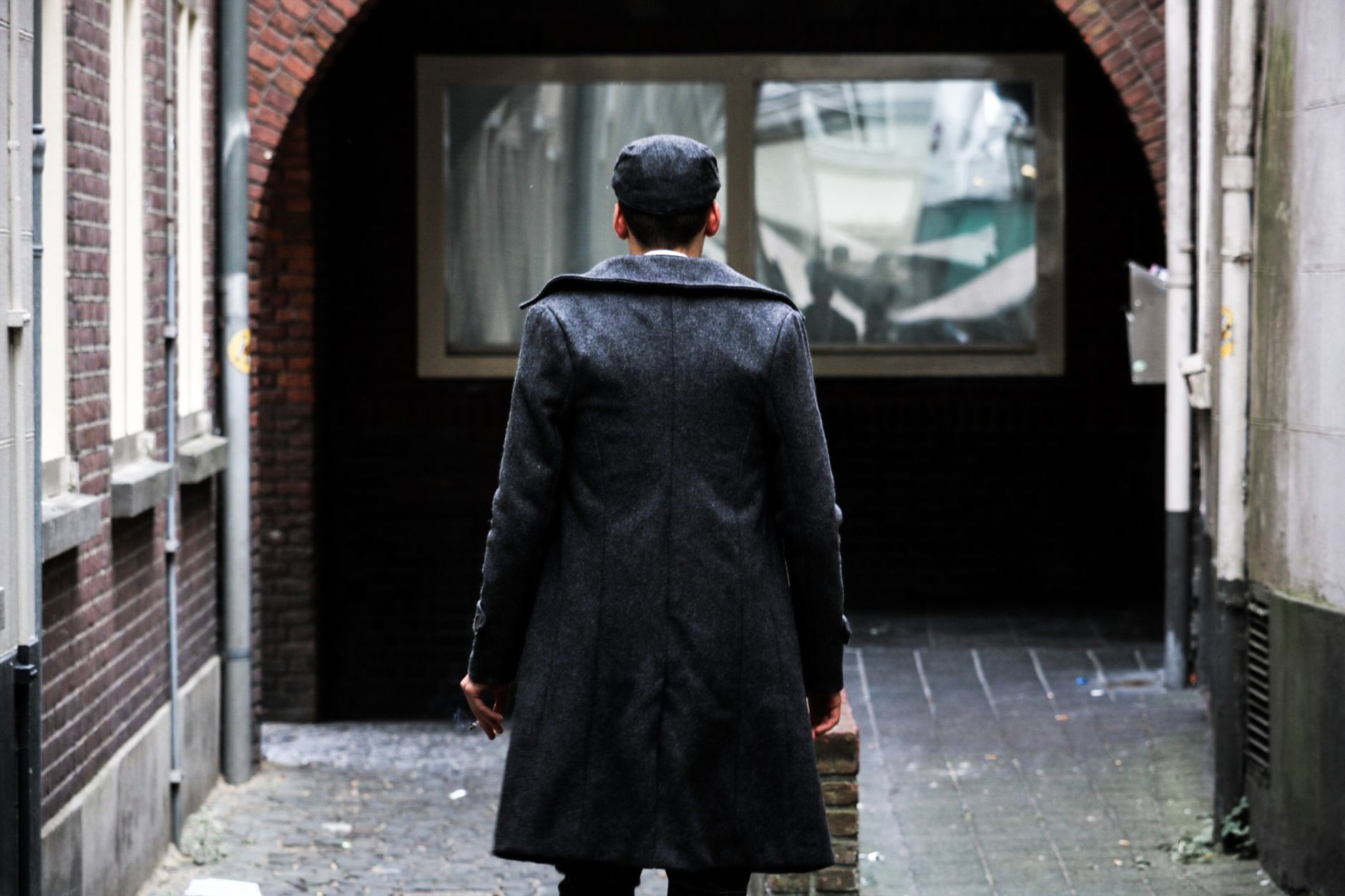 Close-up of the structured back vent on a formal tailored coat showing precise pleat construction