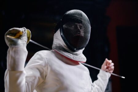Close-up of a fencing plastron showing reinforced vertical chest seams on white protective gear