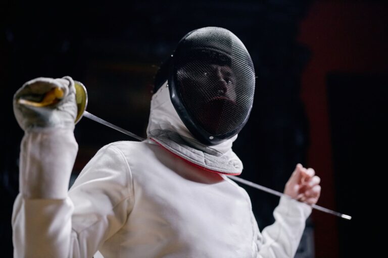 Close-up of a fencing plastron showing reinforced vertical chest seams on white protective gear