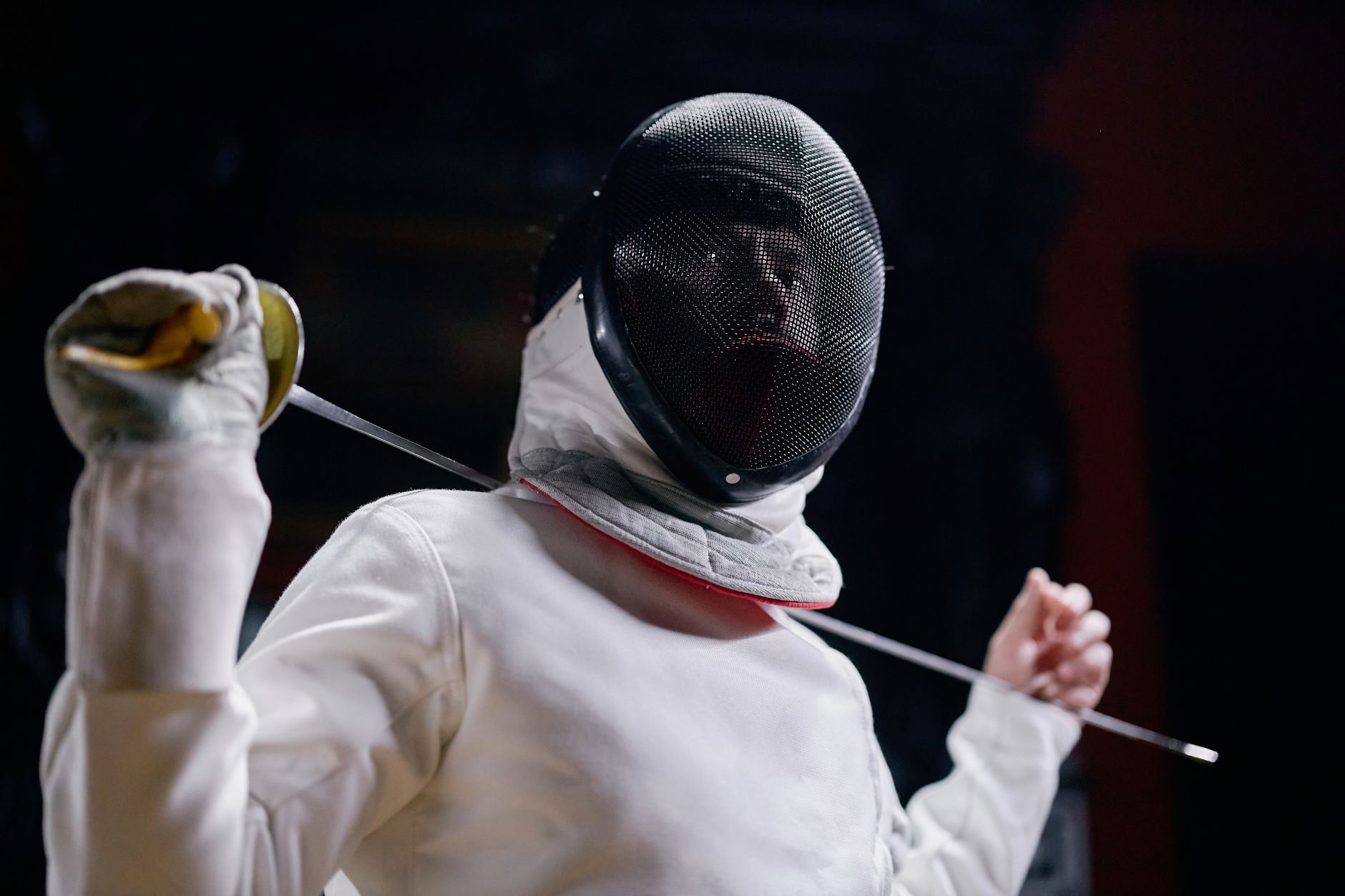 Close-up of a fencing plastron showing reinforced vertical chest seams on white protective gear