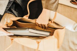 Close-up of a structured leather tote bag showing base detail and material contrast