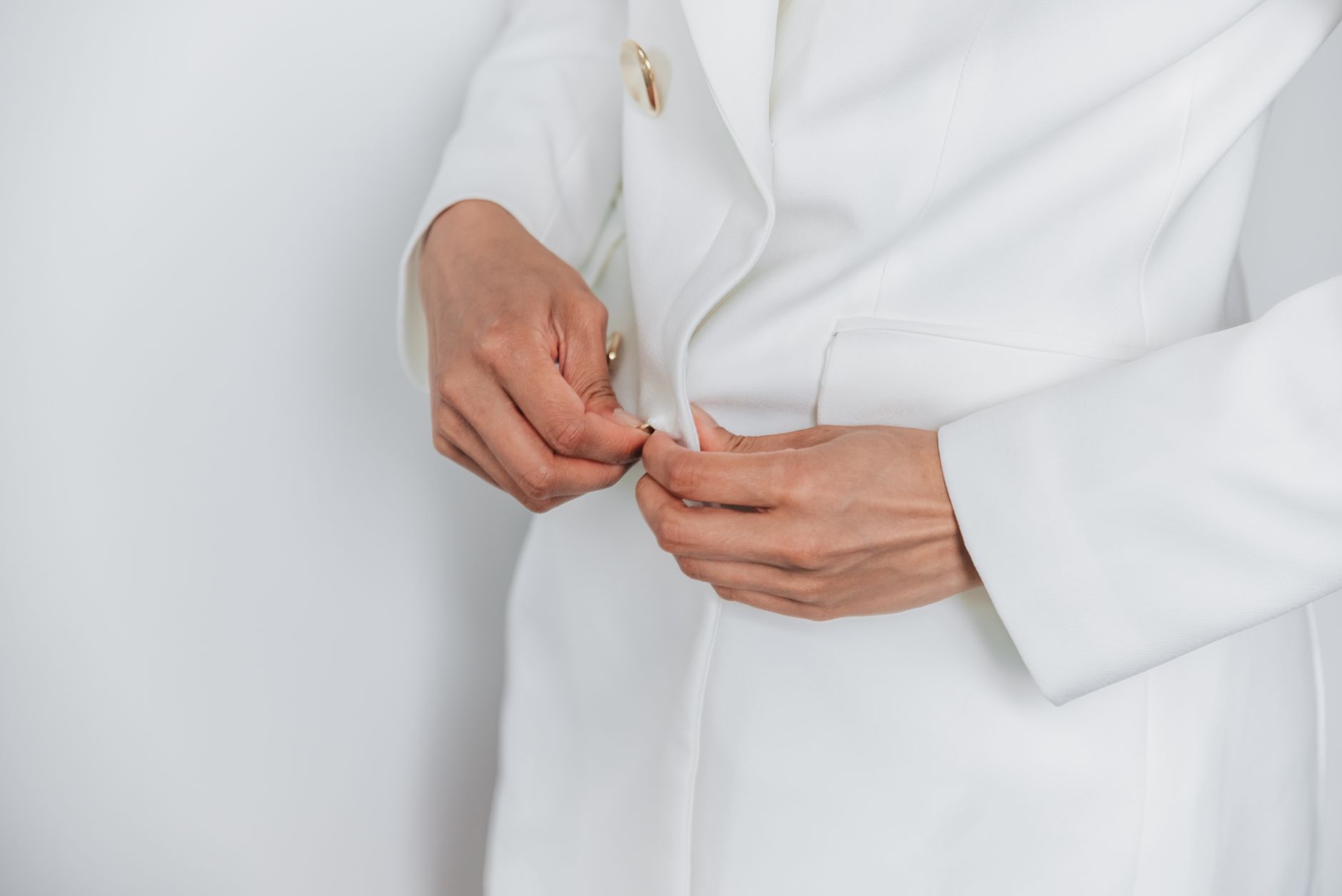 Close-up of a structured jacket sleeve showing a precisely finished cuff hem