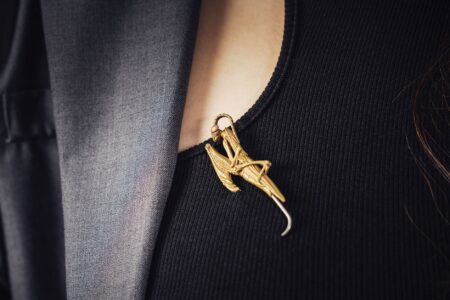 Close-up of minimalist metal hat pins arranged on a dark surface