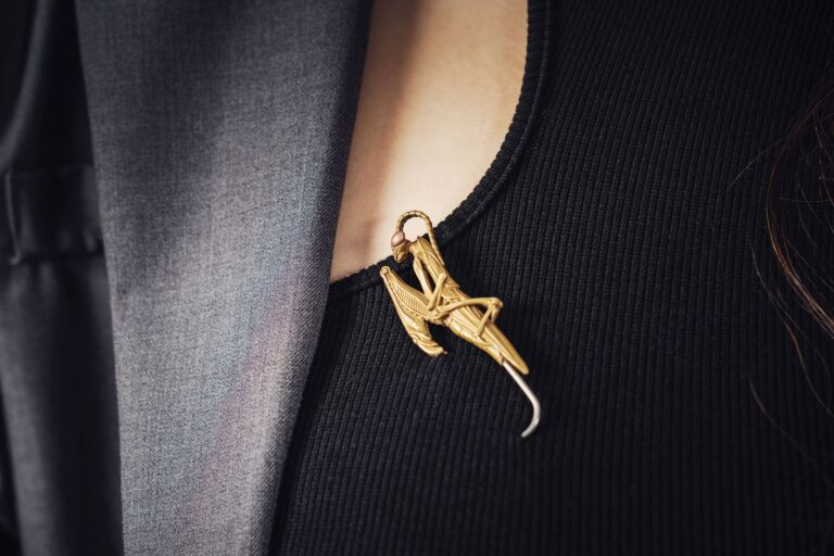 Close-up of minimalist metal hat pins arranged on a dark surface