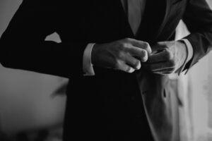 Close-up of tailored jacket sleeve showing button detail at the cuff