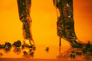 Close-up of structured leather boots with metallic spike hardware details along the shaft