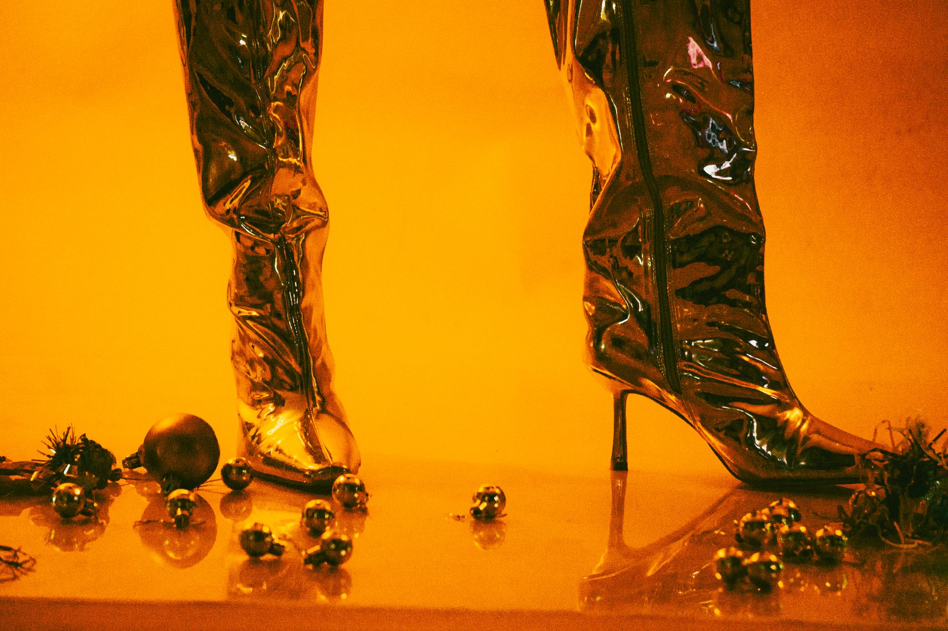 Close-up of structured leather boots with metallic spike hardware details along the shaft