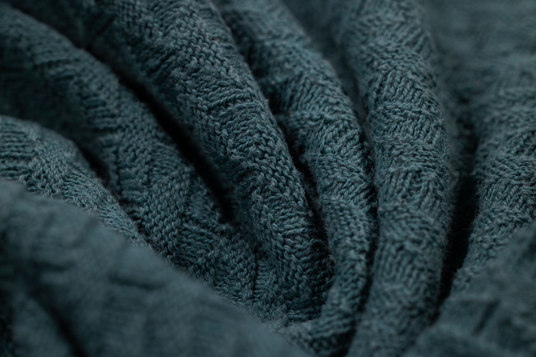 Close-up detail of a structured knit sweater hem showing precise coloured stripe bands