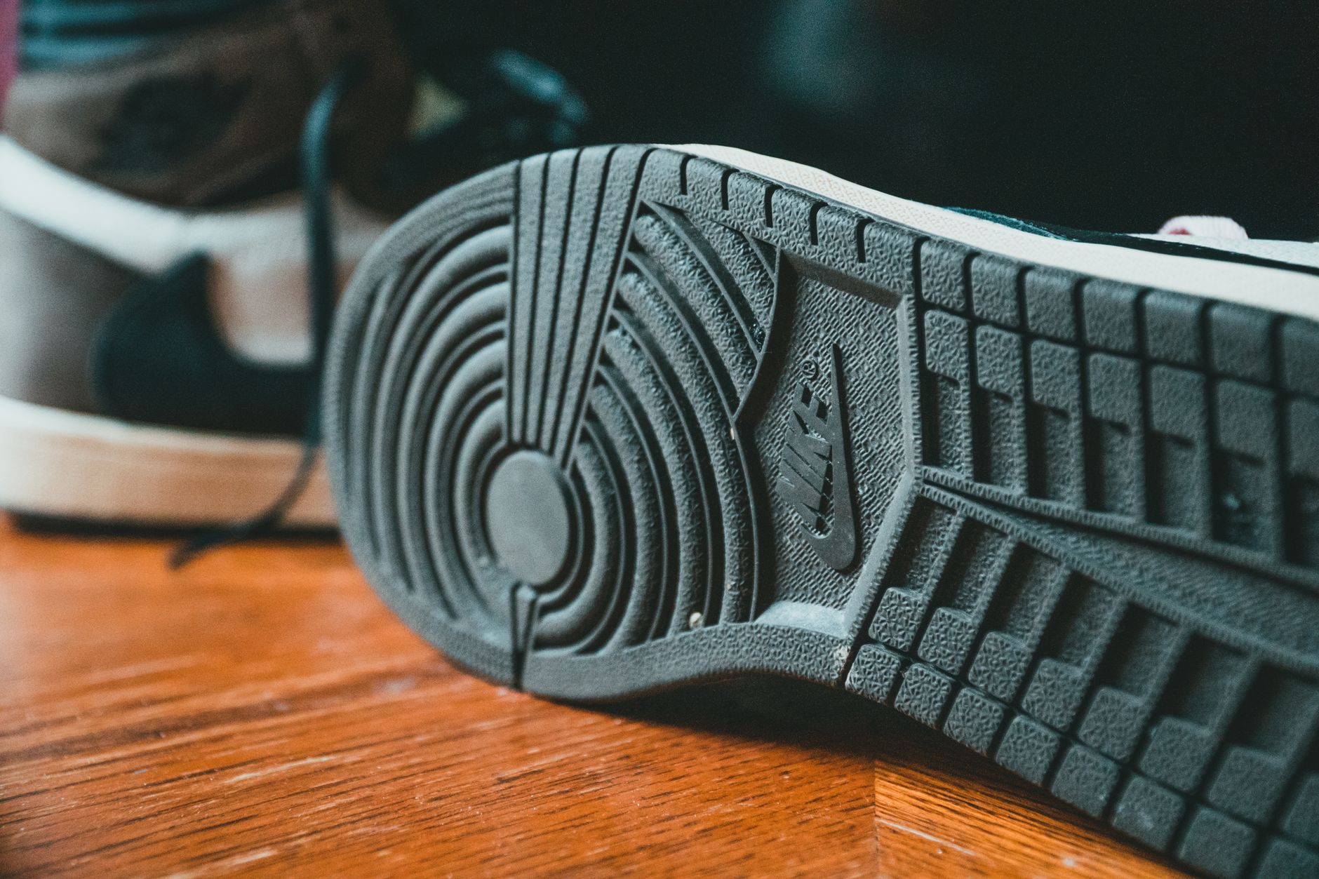 Side profile view of a structured athletic shoe sole showing a continuous curved arc from heel to toe