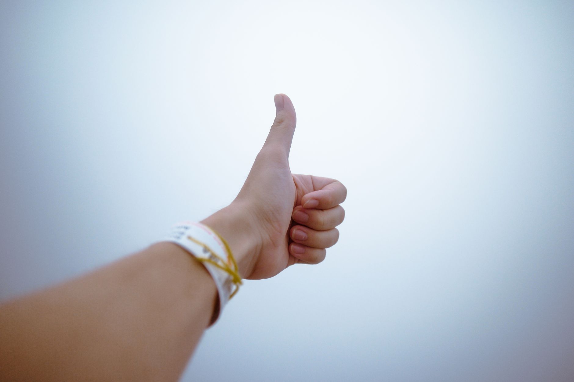 Minimalist leather cuff wristband on a wrist against a neutral background