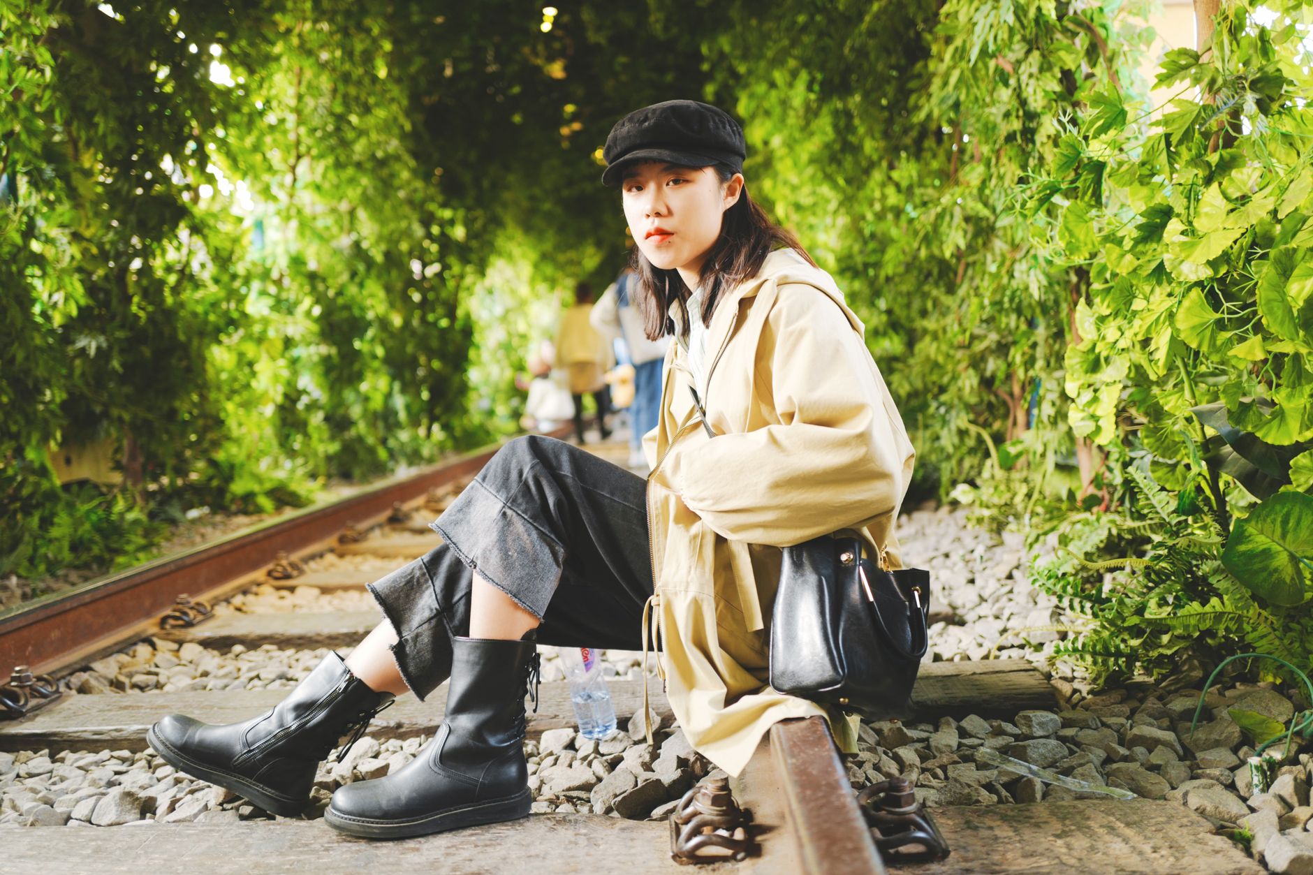 Model wearing structured gaiter boots with strap detail over trousers