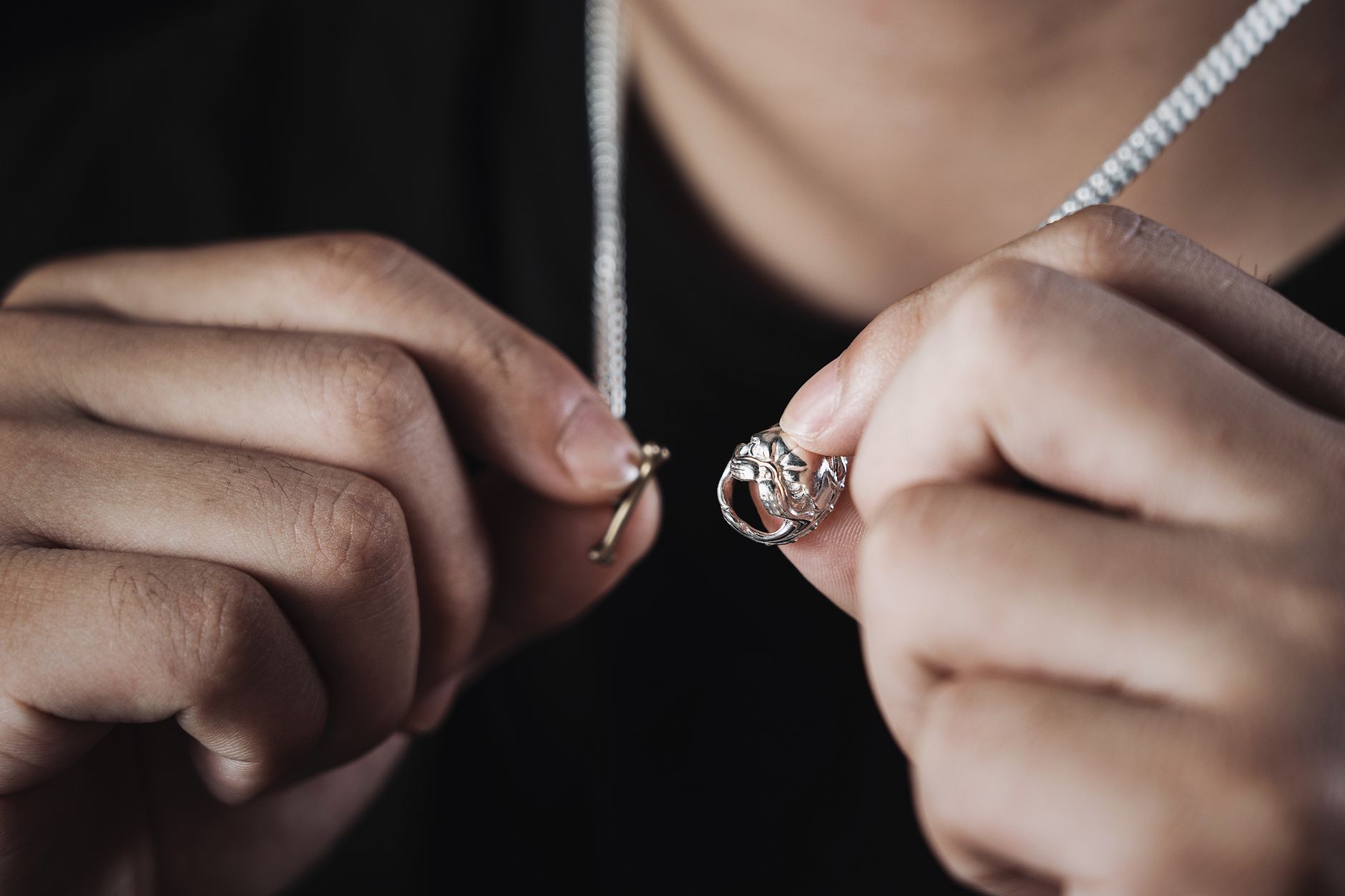 Close-up of a flat braided cord necklace worn against a plain fabric collar