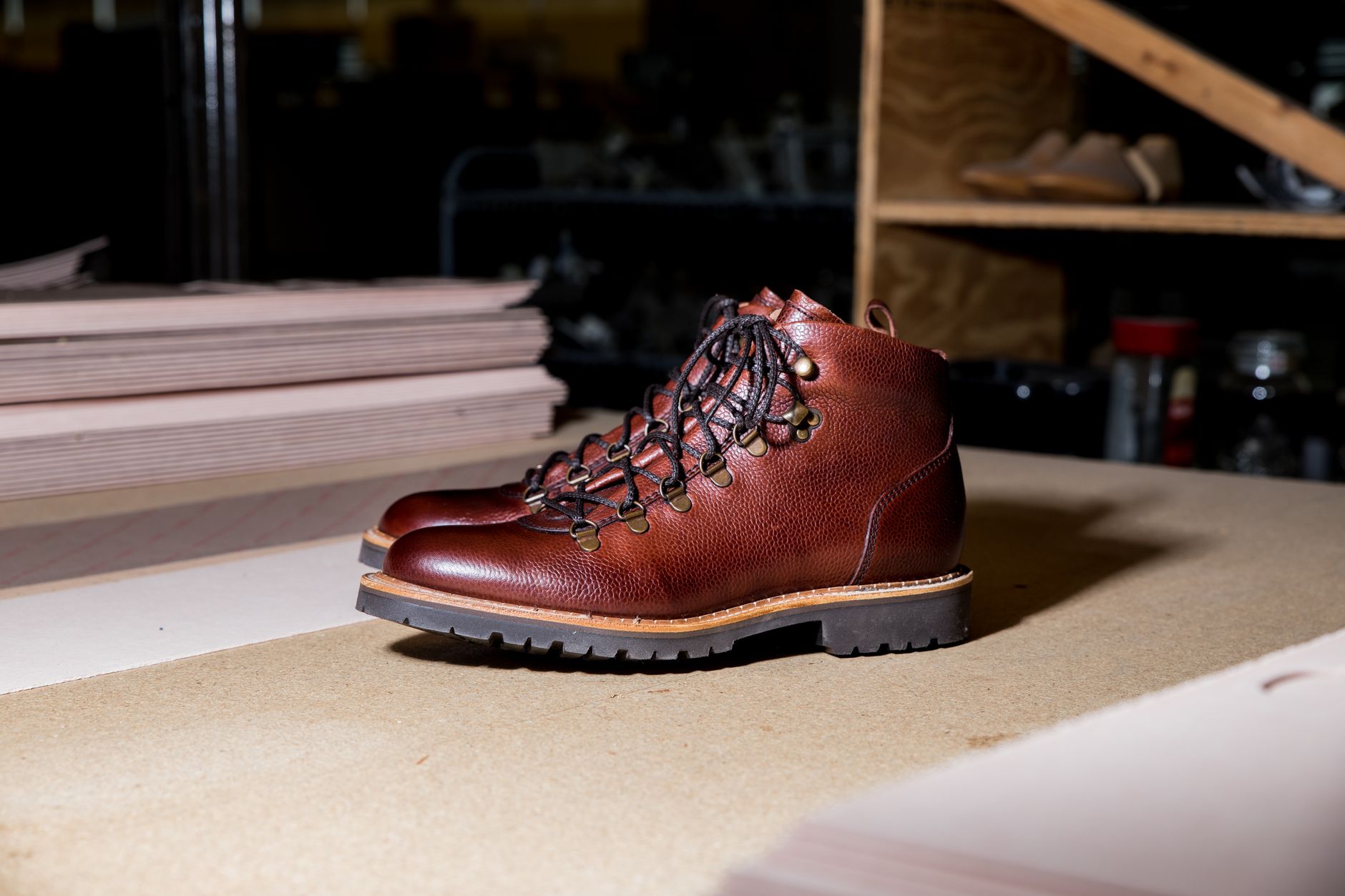 Artisan boot maker working on structured leather toe cap with metal hardware