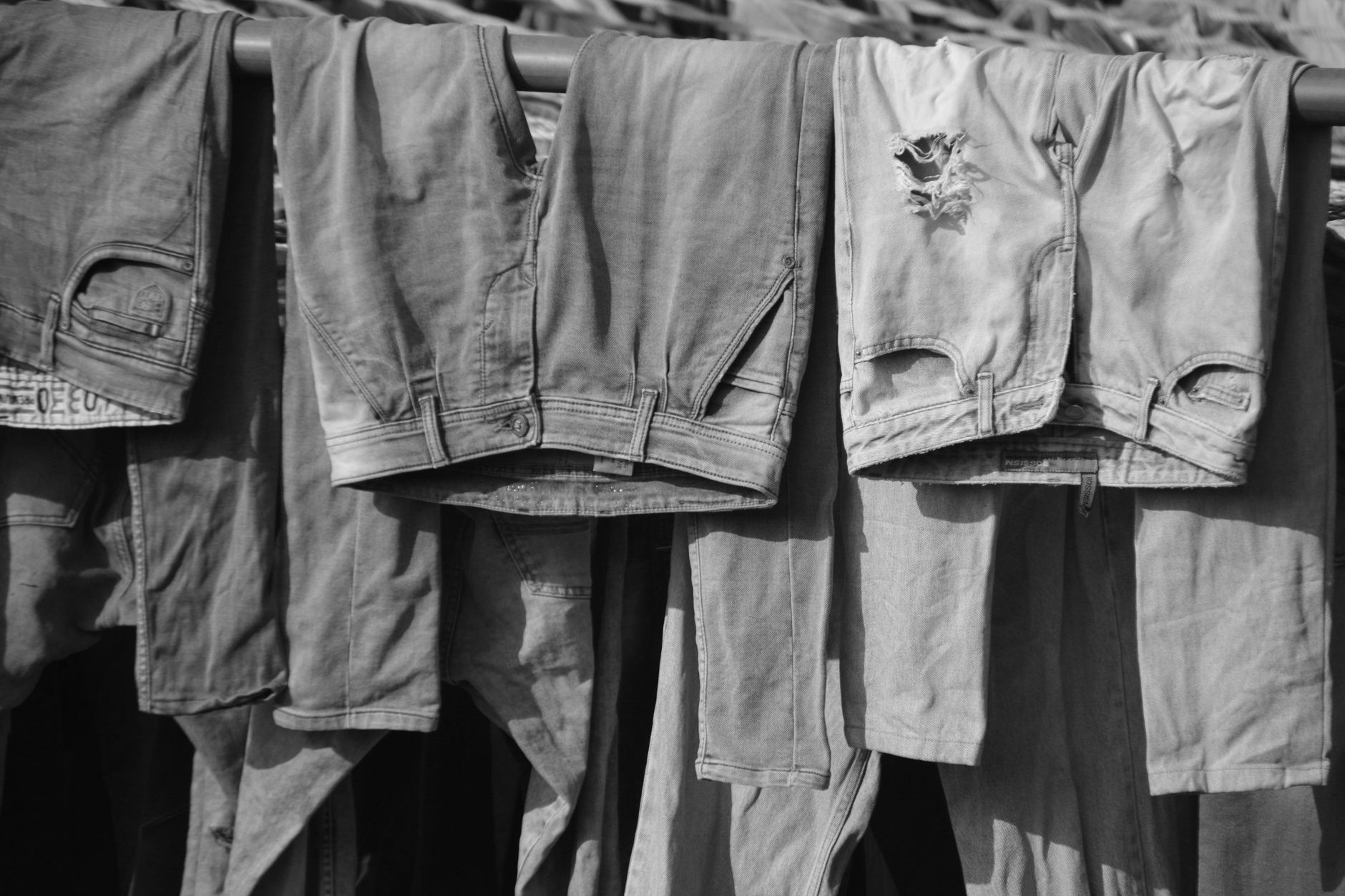 Close-up of dark denim hem showing a graduated bleach fade from deep indigo to pale blue at the edge