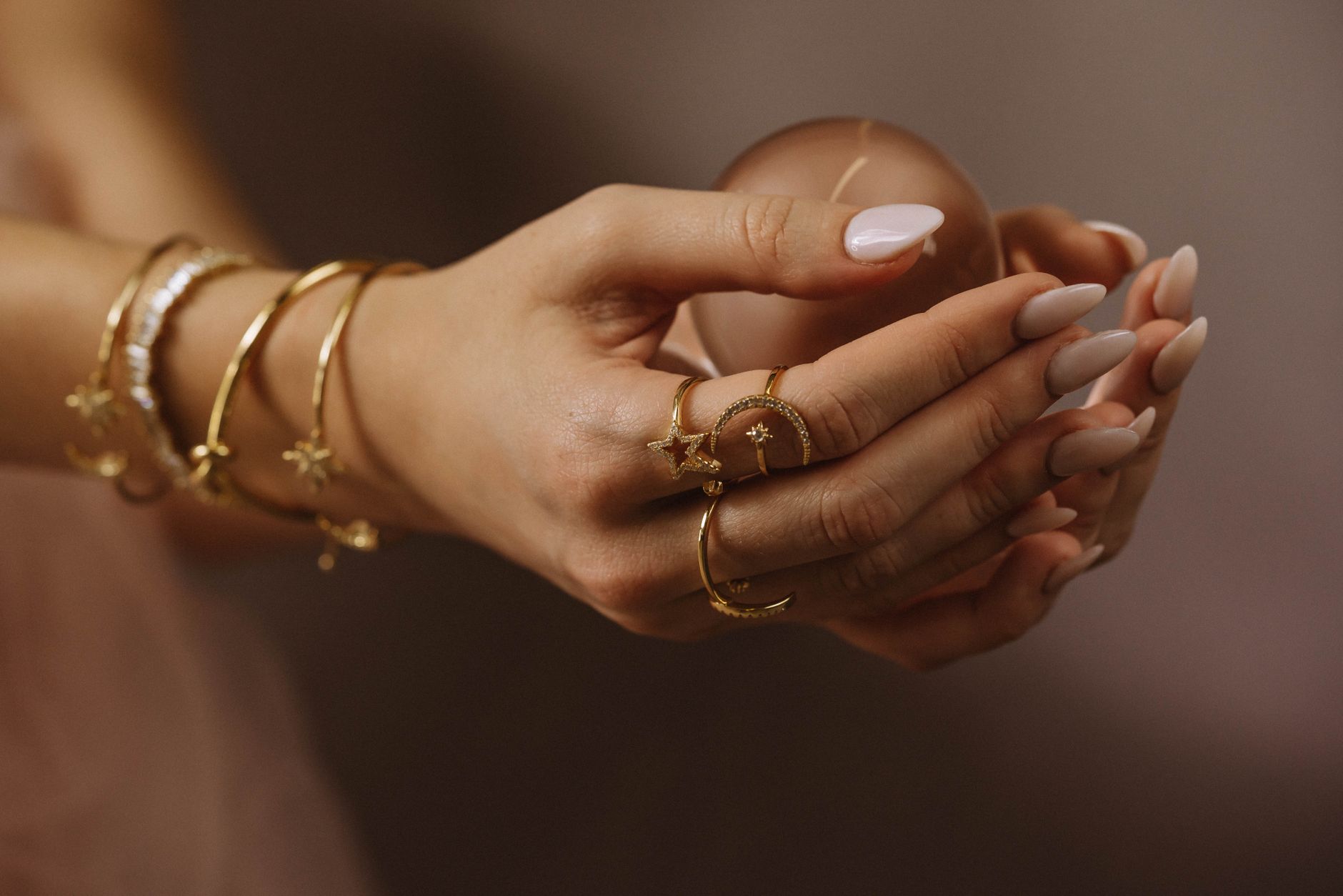 Hand wearing a minimal set of thin metal rings arranged with precise spacing across two fingers